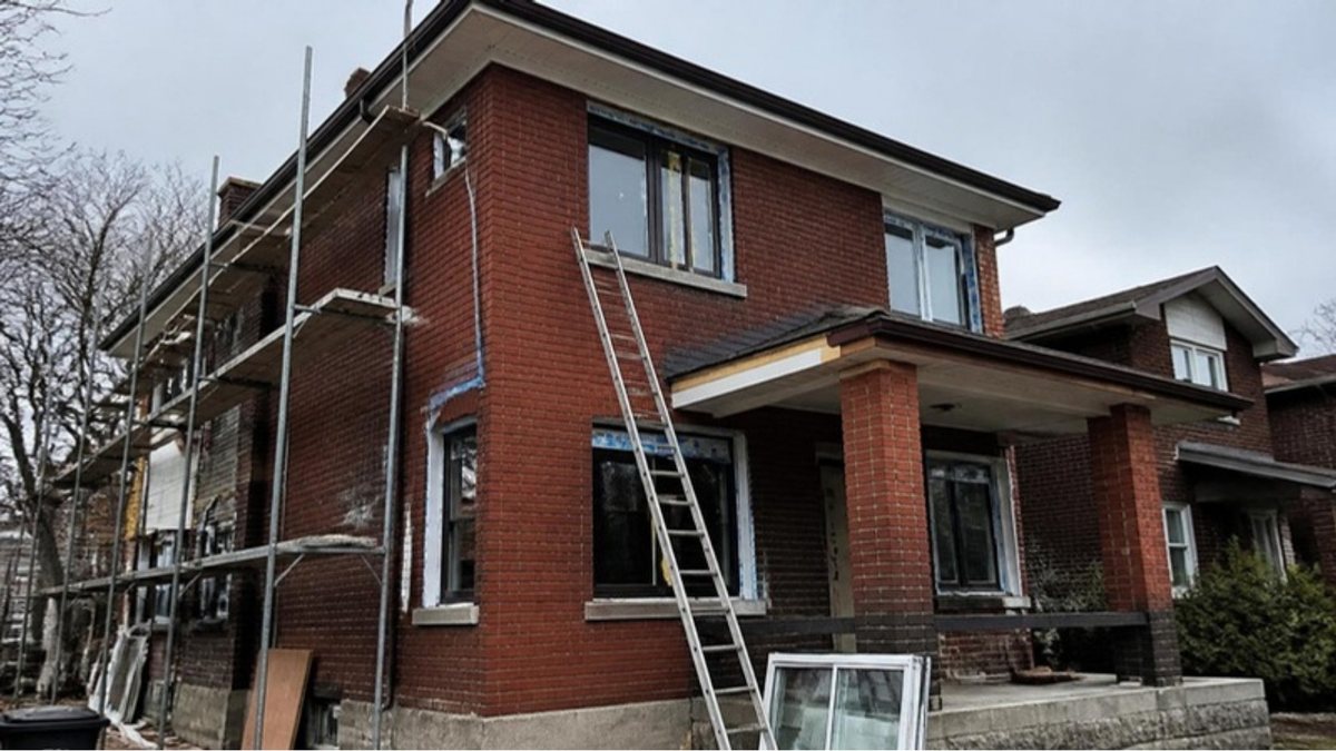 Older brick house in Hamilton under renovation with scaffolding
