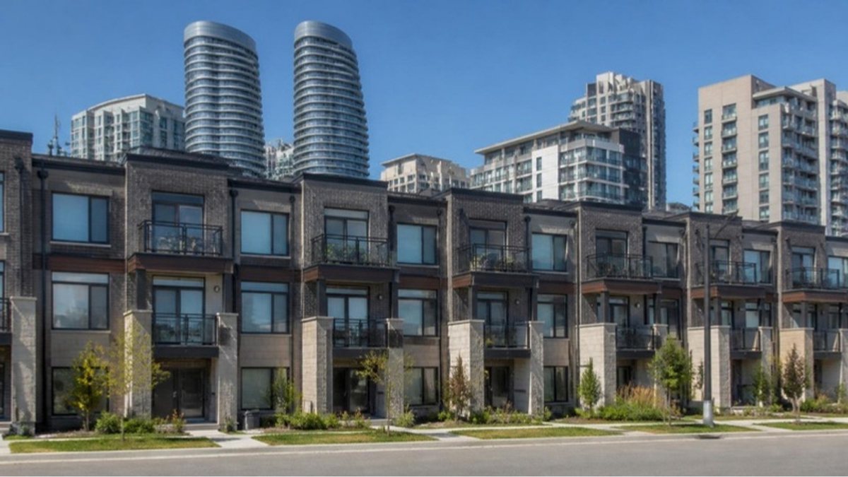 Modern townhouses in Mississauga with condominium towers behind